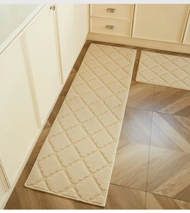Detail view of cream kitchen rug set with geometric patterns on herringbone wood floor