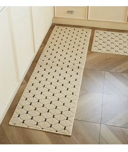 Close-up of minimalist cream kitchen mat with black diamond tufted texture on wood floor