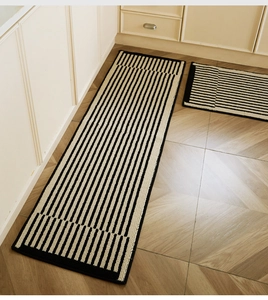 Close-up of black and white geometric striped non-slip kitchen mats with hemmed edges