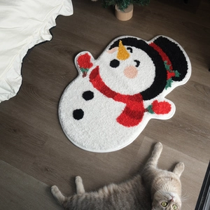 Christmas snowman plush bath mat on dark wood floor with soft shaggy texture