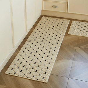 Cream-colored kitchen rug set with black diamond pattern on a wooden floor