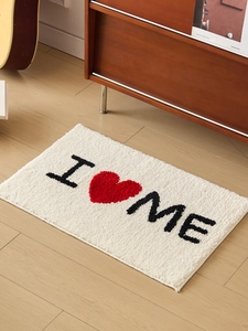 Gros plan du tapis de bain épais avec motif I Heart Me sur parquet vintage