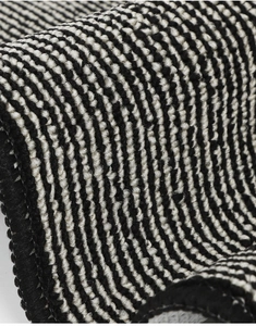 Macro shot of durable black and white striped loop pile doormat with thick edge