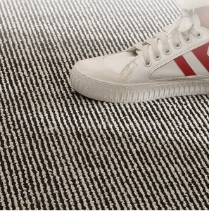 Close-up of black and white striped woven door mat showing textured knit surface details