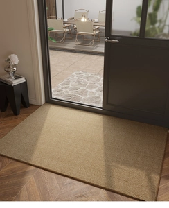 Detail of durable beige entry mat with ribbed texture on herringbone wood flooring