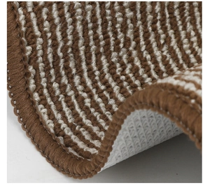 Macro view of brown and white striped door mat showing thick loop pile and non-slip backing