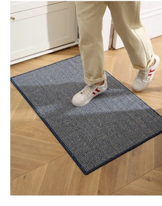 Close-up of durable woven entrance mat in navy blue and beige stripes on wood floor
