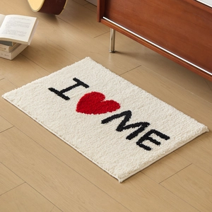 Tapis en peluche crème avec motif cœur I Love Me sur sol en bois dans un décor chaleureux