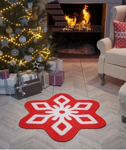 Detailed view of red snowflake christmas rug placed on wooden floor near cozy fireplace