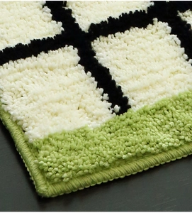 Close-up of thick tufted Bauhaus checkerboard rug with reinforced edges and soft fibers