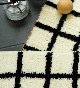 Close-up of thick checkered tufted rug fiber texture and high-density plush pile surface