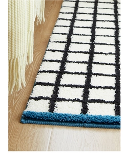 Close-up of Bauhaus runner rug with thick checkered tufting and blue border trim