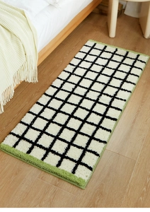 Close-up of Bauhaus checkered bedside rug with soft flocked texture on wooden floor