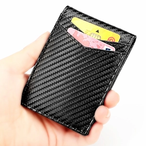 Slim RFID carbon fiber wallet held in hand showing dual card slots and textured finish