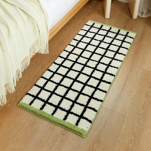 Long Bauhaus style black and white checkered carpet with green edges on wood floor