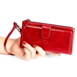 Close-up of a premium red leather long wallet for women with zipper and wristlet strap