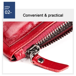 Detail of red leather wallet featuring a durable metal zipper and reinforced leather puller