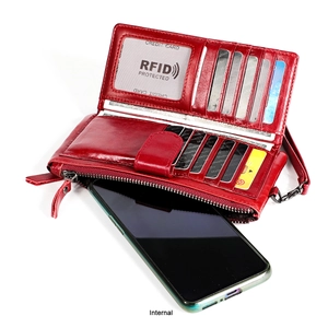 Macro detail of red oil-wax leather wallet showing RFID blocking and multi-card storage