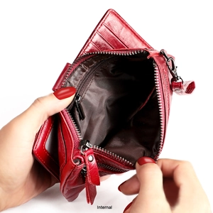 Macro detail of the red genuine leather wallet interior showing multiple card slots and zipper pocket