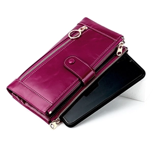 Detail of dark purple leather wallet with three gold zipper layers holding a smartphone