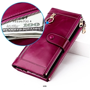 Detailed view of magenta oil wax leather wallet featuring multiple gold zipper compartments