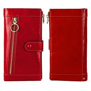 Macro view of vintage red oil wax leather wallet with gold zipper and white stitching