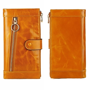 Detail of vintage yellow oil wax leather wallet with gold ring zipper and snap closure