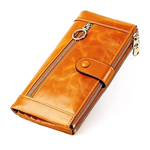 Detail of vintage caramel brown leather wallet showing stitching and metal hardware