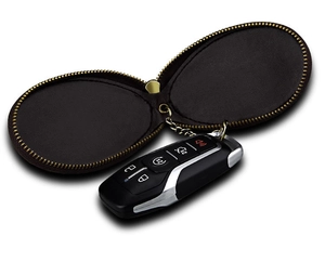Detail view of a vintage leather car key case with metal zipper and internal chain