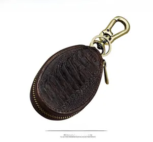 Detailed front view of dark brown crocodile pattern leather car key case with brass hook