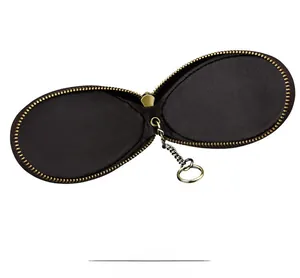 Macro shot of dark brown leather car key case with vintage brass zipper and inner chain