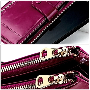 Detail of burgundy leather phone wallet with white stitching and gold dual zippers