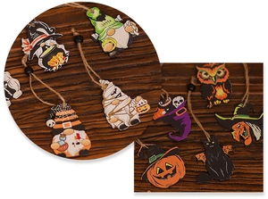 Close-up of wooden Halloween ornaments featuring gnomes, pumpkins, and witches on jute strings