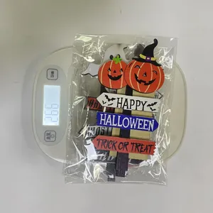 Detailed view of Halloween wooden pumpkin ornaments and ghosts on a digital scale
