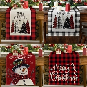 Detail of Christmas table runner with festive prints and durable linen texture on wood table