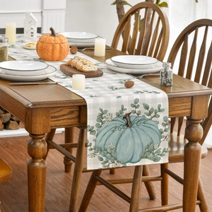 Detailed view of linen table runner featuring blue pumpkin and eucalyptus leaves
