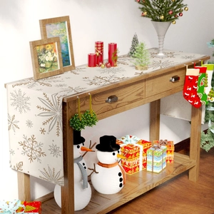 Close-up of linen table runner with gold snowflake patterns for Christmas table decor