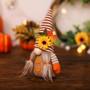 Gnomo di peluche autunnale con cappello di girasoli e foglie su sfondo rustico in legno
