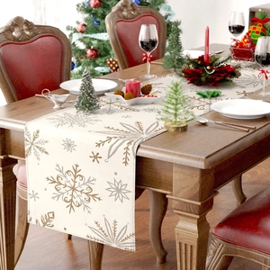 Detail of Christmas table runner featuring gold and silver snowflakes on linen fabric
