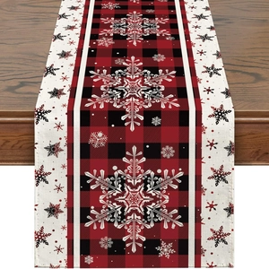 Detail of red and black buffalo plaid table runner with white snowflake patterns