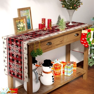 Detail of linen Christmas table runner with red black buffalo plaid and snowflake patterns