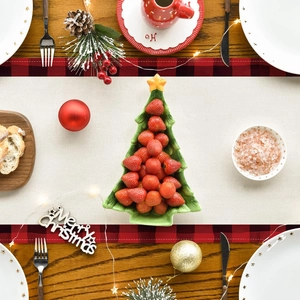 Close-up of a green ceramic Christmas tree shaped plate filled with fresh strawberries