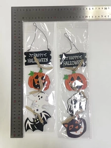 Macro view of wooden Happy Halloween hanging signs with pumpkin and ghost motifs