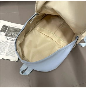 Top view of spacious main compartment in light blue nylon backpack with beige lining