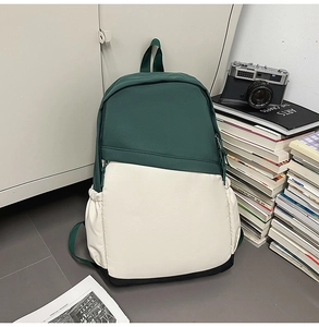 Detail view of a green and white canvas backpack in a stylish indoor lifestyle setting