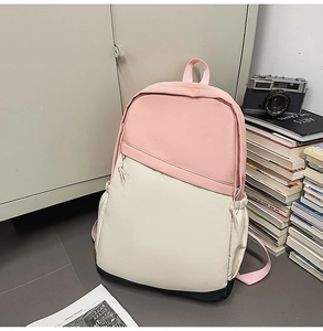 Detailed shot of a color-block waterproof nylon commuter backpack in a modern studio setting