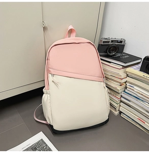 Detailed view of a pink and white canvas backpack with a sleek diagonal zipper pocket