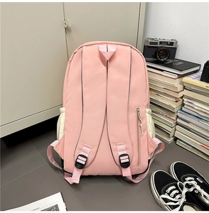 Detail view of pink backpack featuring adjustable straps and anti-theft zipper pocket