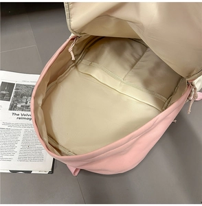 Detail view of pink nylon backpack interior with laptop compartment and smooth lining