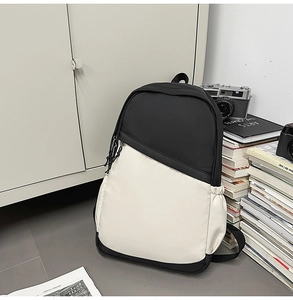 Close-up of minimalist black and white waterproof nylon backpack with side pockets and zippers